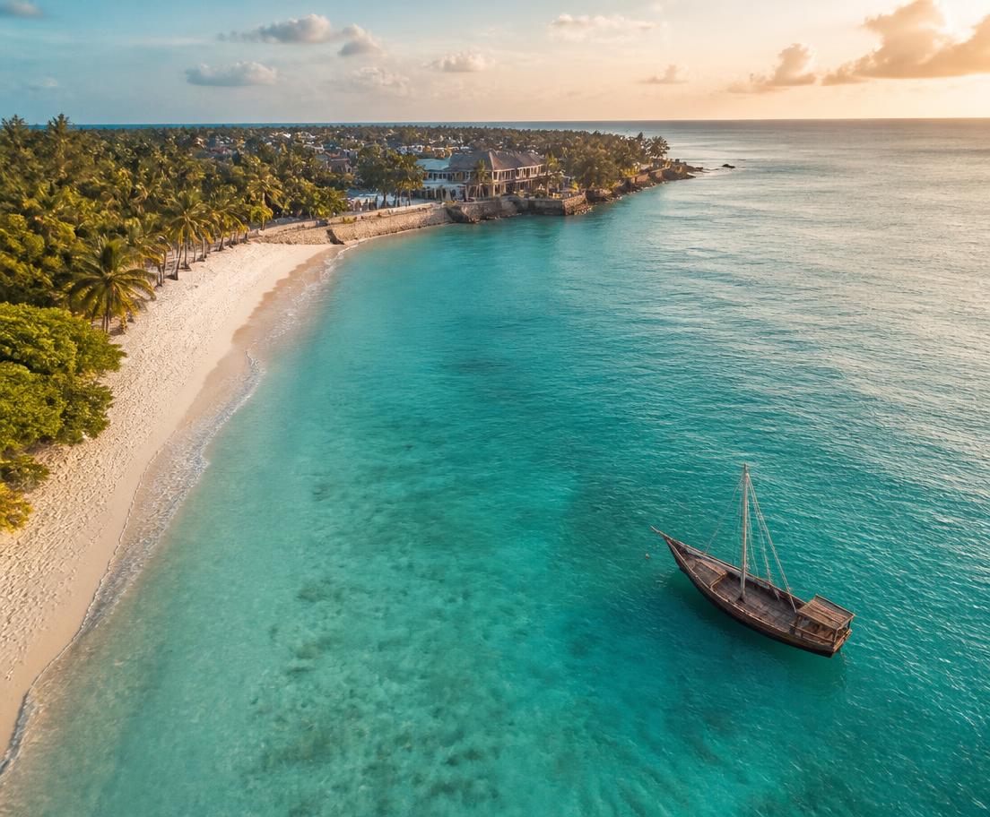 Costa di Zanzibar vista dall'alto, con oceano turchese e un dhow all'ancora